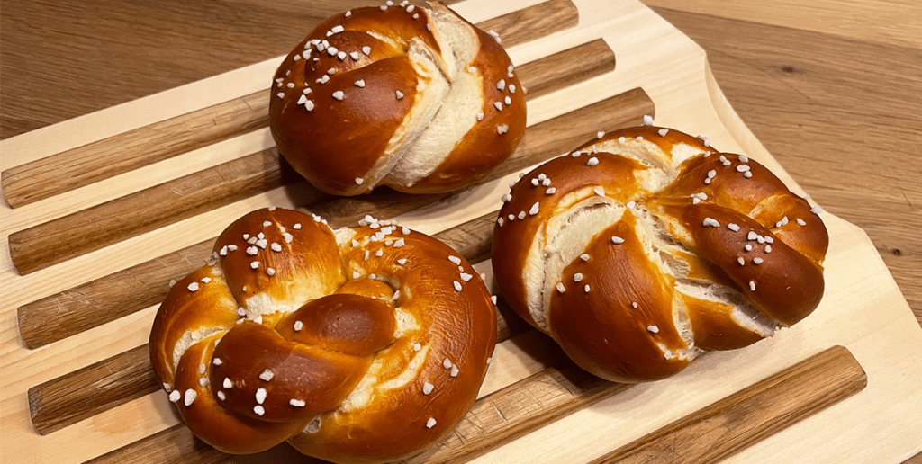 drei fertig gebackene Laugengebäcke geformt als Knoten