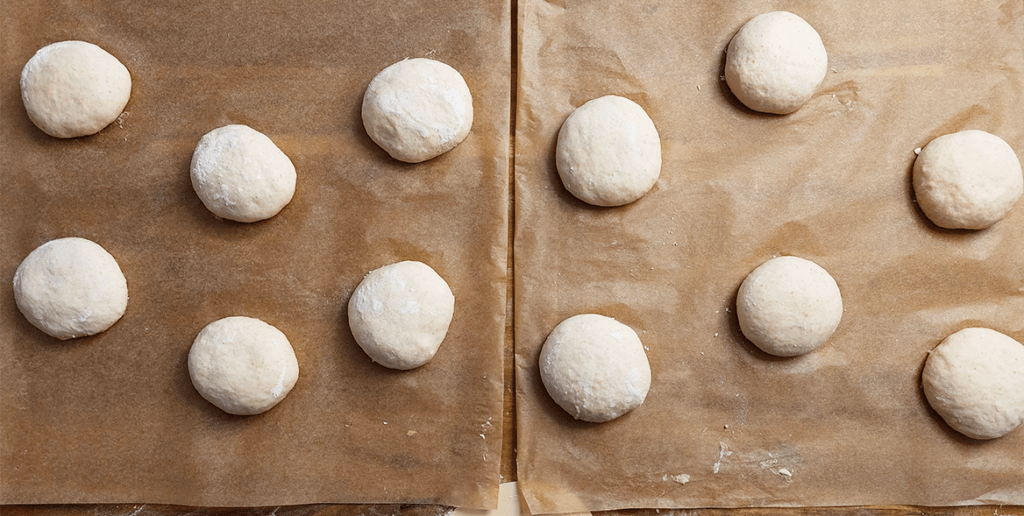 die Rohlinge der Burger-Buns liegen auf Backpapier